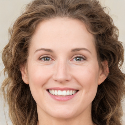 Joyful white young-adult female with long  brown hair and green eyes