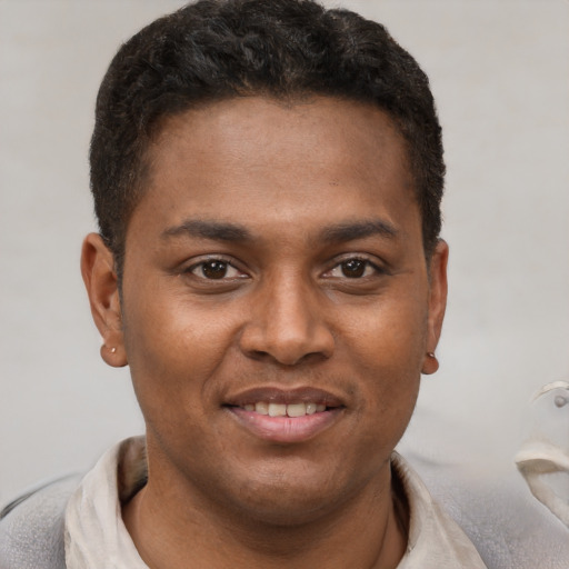 Joyful black young-adult male with short  brown hair and brown eyes