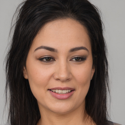 Joyful latino young-adult female with long  brown hair and brown eyes