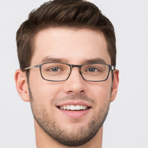 Joyful white young-adult male with short  brown hair and grey eyes