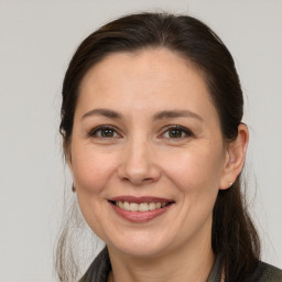 Joyful white adult female with medium  brown hair and brown eyes