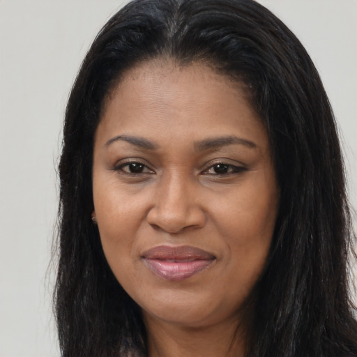 Joyful black young-adult female with long  brown hair and brown eyes