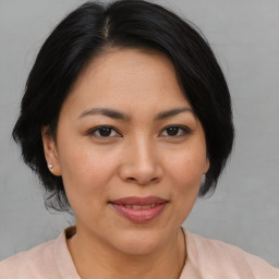 Joyful asian adult female with medium  brown hair and brown eyes