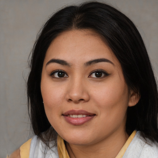 Joyful latino young-adult female with medium  brown hair and brown eyes