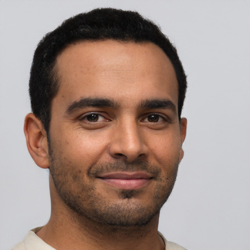 Joyful latino young-adult male with short  brown hair and brown eyes