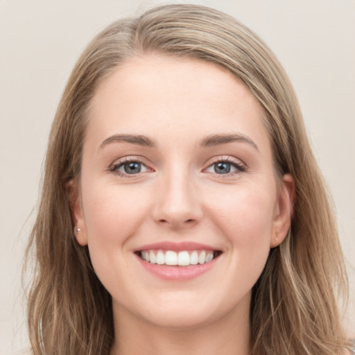 Joyful white young-adult female with long  brown hair and blue eyes