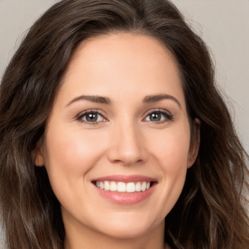 Joyful white young-adult female with long  brown hair and brown eyes