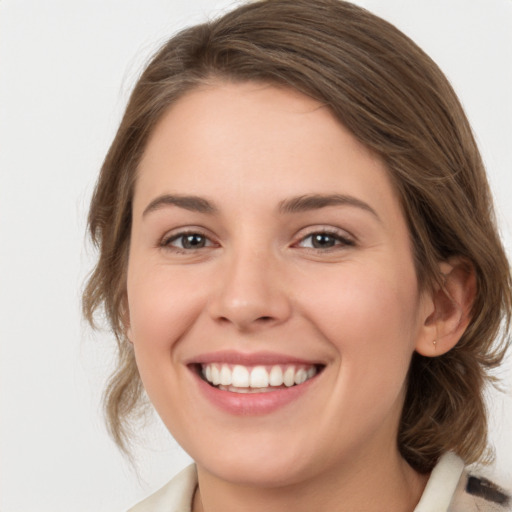 Joyful white young-adult female with medium  brown hair and green eyes