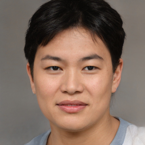 Joyful asian young-adult female with short  brown hair and brown eyes
