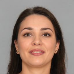 Joyful white young-adult female with long  brown hair and brown eyes