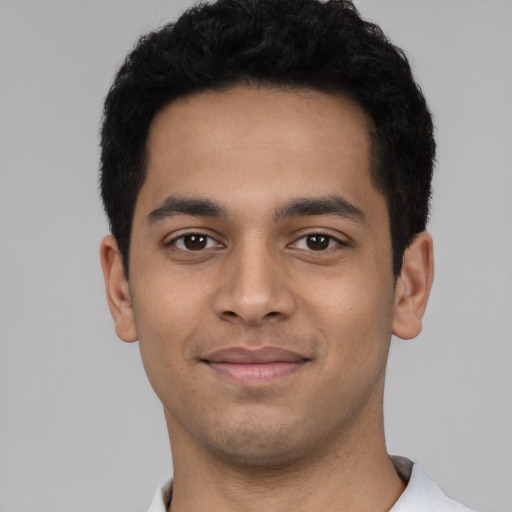 Joyful latino young-adult male with short  black hair and brown eyes