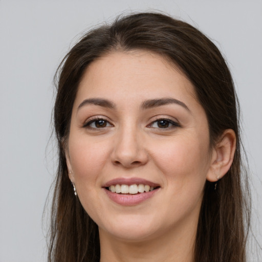 Joyful white young-adult female with long  brown hair and brown eyes