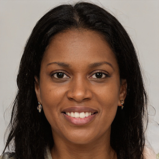 Joyful black young-adult female with long  brown hair and brown eyes