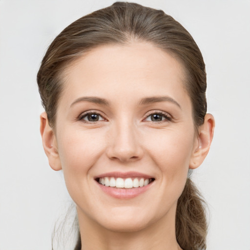 Joyful white young-adult female with medium  brown hair and grey eyes