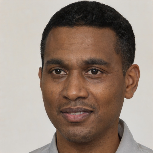 Joyful black young-adult male with short  black hair and brown eyes
