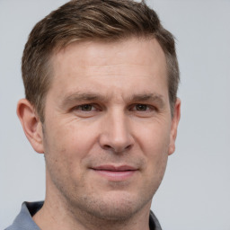 Joyful white adult male with short  brown hair and grey eyes