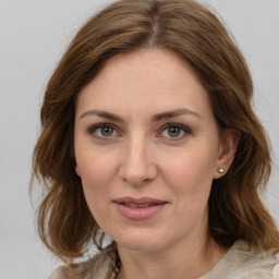 Joyful white young-adult female with medium  brown hair and green eyes