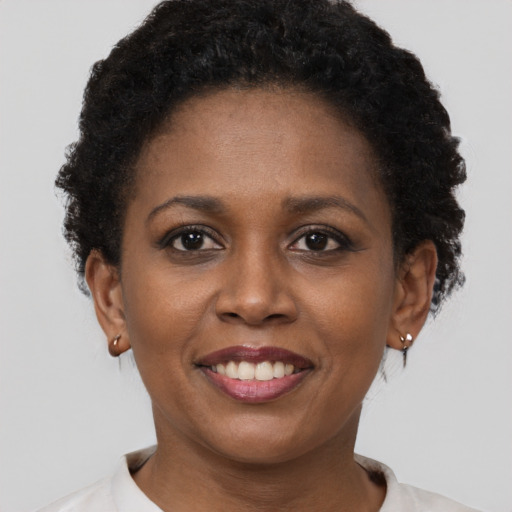 Joyful black young-adult female with short  brown hair and brown eyes
