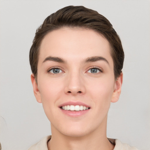 Joyful white young-adult female with short  brown hair and grey eyes