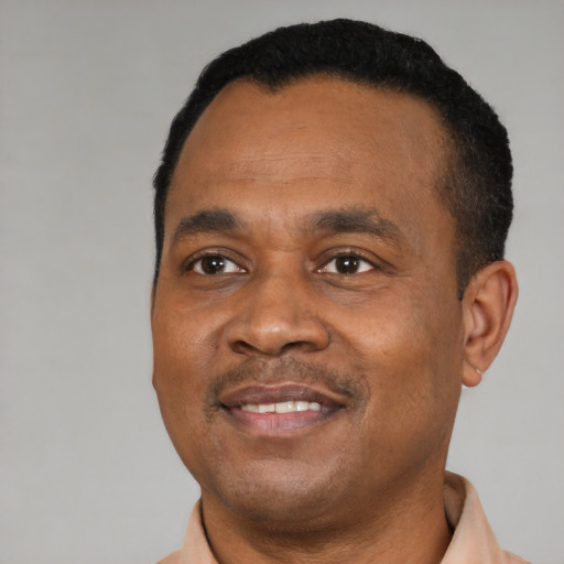 Joyful black adult male with short  black hair and brown eyes
