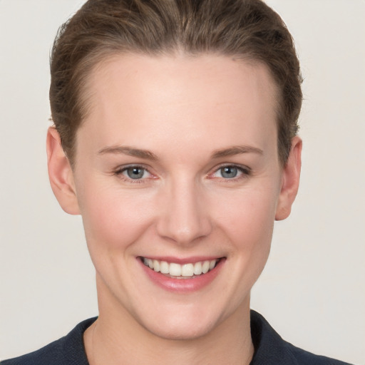 Joyful white young-adult female with short  brown hair and grey eyes