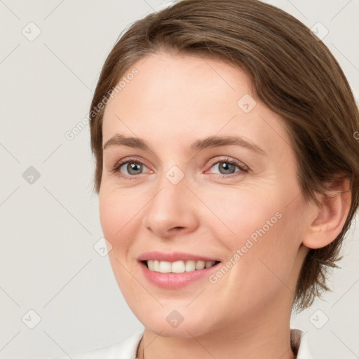 Joyful white young-adult female with medium  brown hair and grey eyes