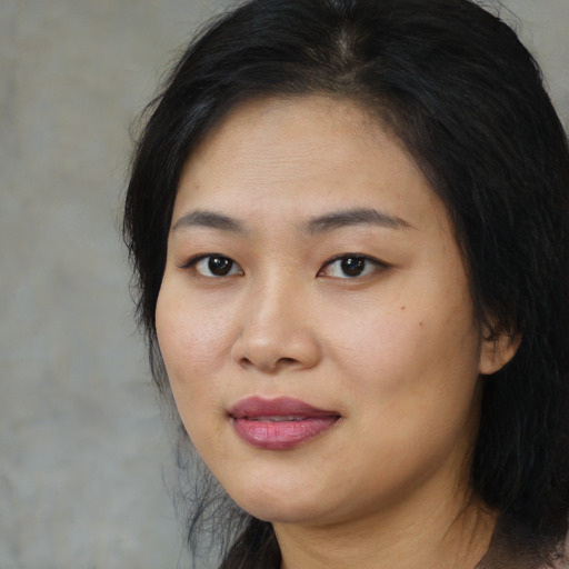 Joyful asian young-adult female with long  black hair and brown eyes