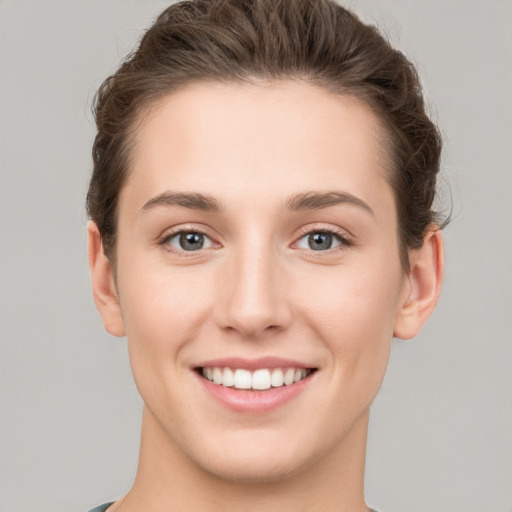 Joyful white young-adult female with short  brown hair and grey eyes