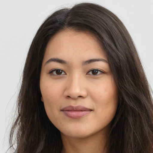 Joyful latino young-adult female with long  brown hair and brown eyes