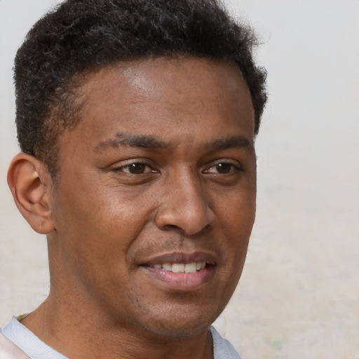 Joyful latino young-adult male with short  brown hair and brown eyes