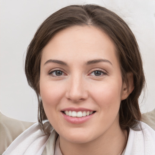 Joyful white young-adult female with medium  brown hair and grey eyes