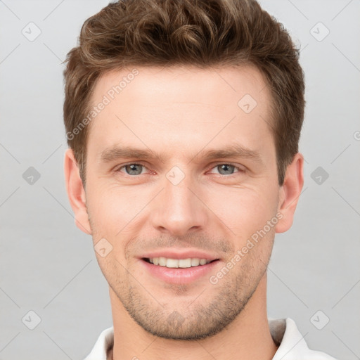 Joyful white young-adult male with short  brown hair and grey eyes