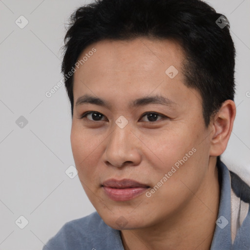 Joyful asian young-adult male with short  black hair and brown eyes