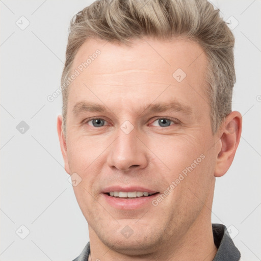 Joyful white adult male with short  brown hair and grey eyes