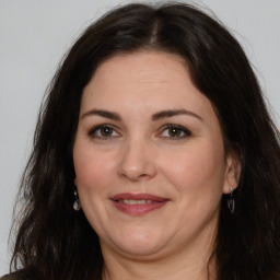 Joyful white adult female with long  brown hair and brown eyes