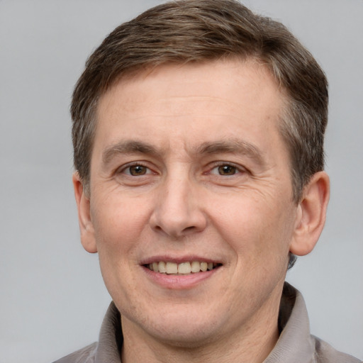 Joyful white adult male with short  brown hair and grey eyes