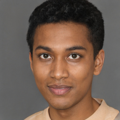 Joyful black young-adult male with short  brown hair and brown eyes