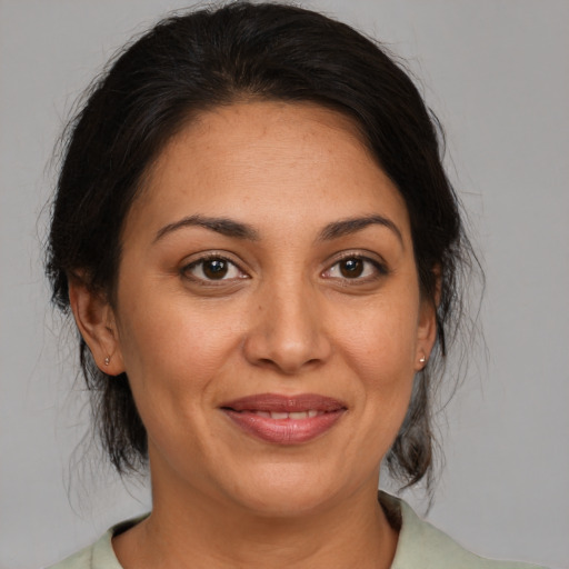 Joyful latino adult female with medium  brown hair and brown eyes