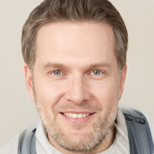 Joyful white adult male with short  brown hair and grey eyes