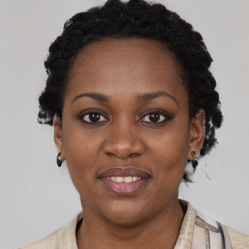 Joyful black young-adult female with short  black hair and brown eyes