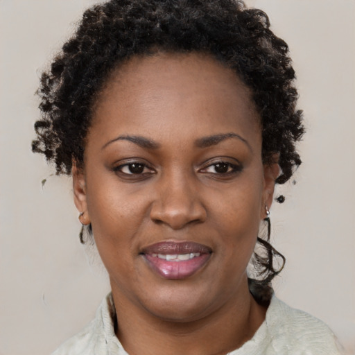 Joyful black adult female with short  brown hair and brown eyes