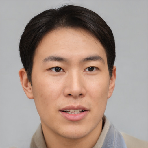 Joyful asian young-adult male with short  brown hair and brown eyes