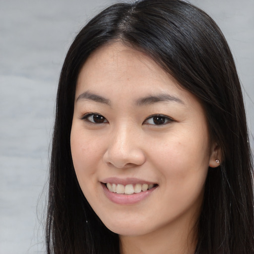 Joyful asian young-adult female with long  brown hair and brown eyes
