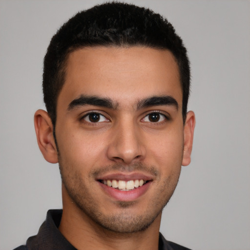 Joyful latino young-adult male with short  brown hair and brown eyes