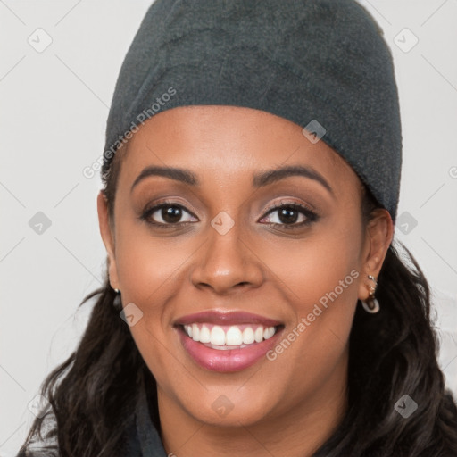 Joyful black young-adult female with long  black hair and brown eyes