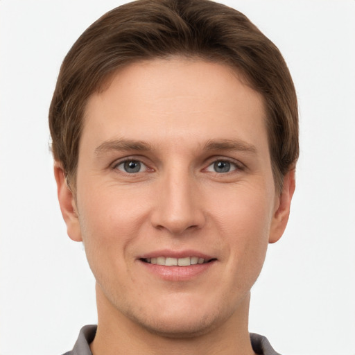 Joyful white young-adult male with short  brown hair and grey eyes