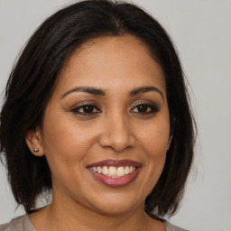 Joyful latino young-adult female with medium  brown hair and brown eyes