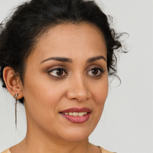 Joyful latino young-adult female with short  brown hair and brown eyes