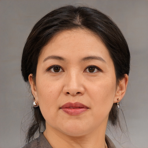 Joyful asian adult female with medium  brown hair and brown eyes