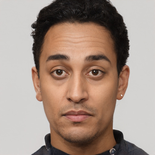 Joyful latino young-adult male with short  black hair and brown eyes